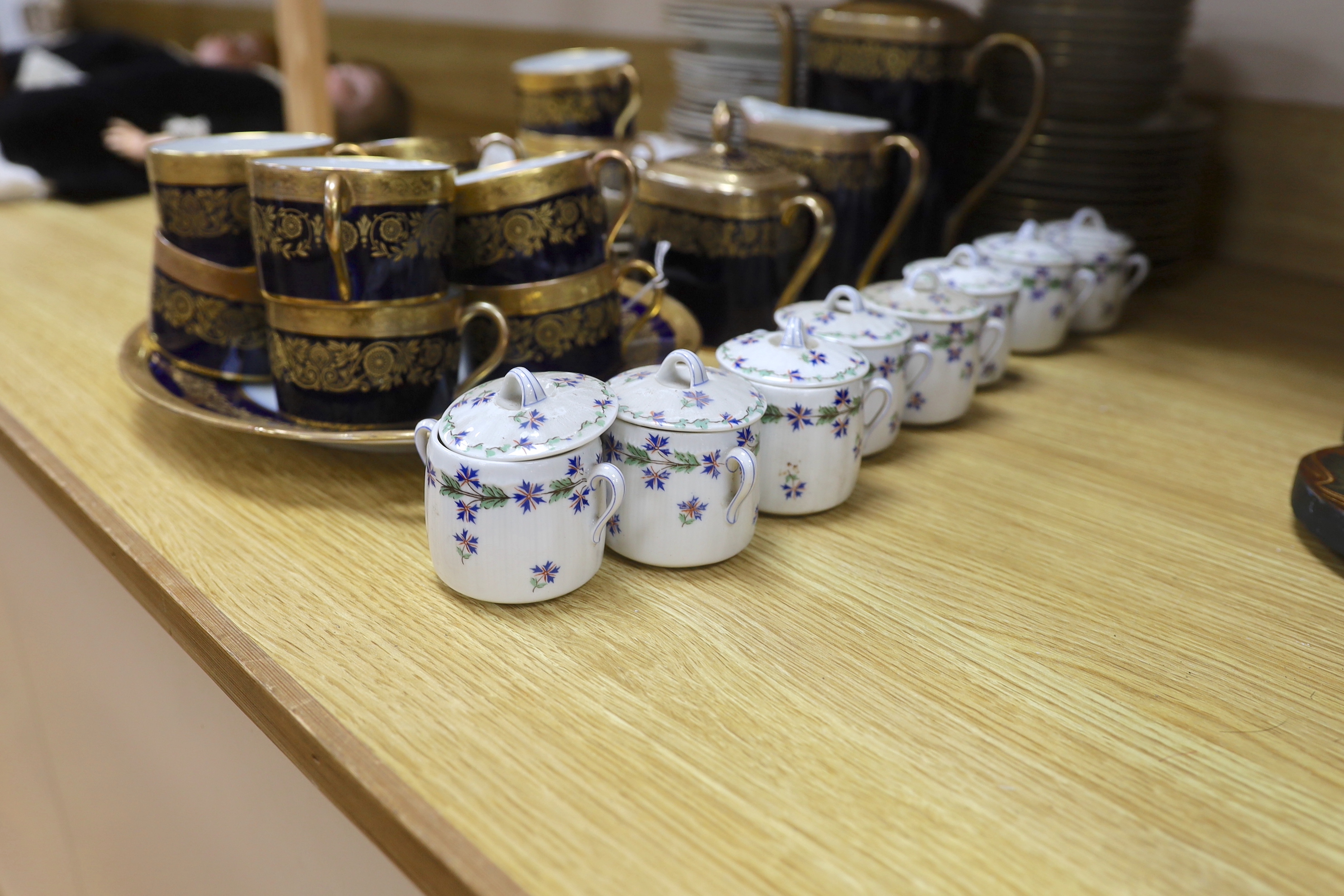 A Raynaud and Co. Limoges gilt and navy ten cup coffee service, a Woodsware part dinner service and eight Limoges floral pots and covers